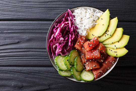 Raw Organic Ahi Tuna Poke Bowl with Rice and Veggies close-up. Horizontal top view