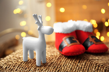 Decorative deer and Christmas baby booties on blurred background