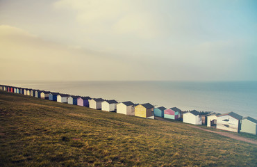Blue sky and colorful beach huts along the coastline of Whitstable - retro styled photo