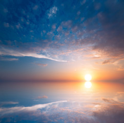A beautiful sunset is reflected in the sea as in a mirror.