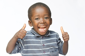 Very happy African black boy making thumbs up sign with hands laughing happily (African ethnicity black boy isolated on white)