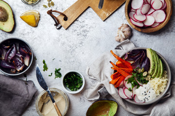 Fresh healthy vegetarian bowl for lunch with baked carrots and red onion, coucous and sliced avocado. Simple and colourful organic food concept. Flat lay with copy space.