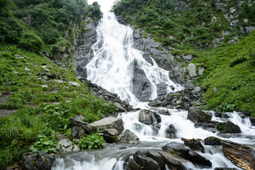 Travel to the waterfall  Balea in Fagarash mountains. Rocky waterfall in the mountains. The place of Carpathians Romania, near the Transfagarasan road.

