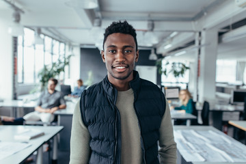 African male designer standing in modern office - Powered by Adobe