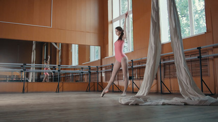 Graceful girl ballerina practicing in the Studio, elements of dance