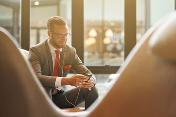 Cheerful businessman listening to music