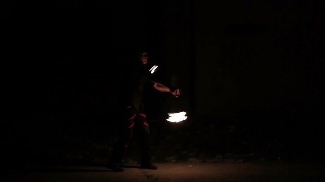 Male fire show performer at night. Poi performance.