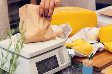 a person cut a cheese in the cheese market.