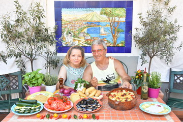 Uomo e Donna italiani preparano una pietanza italiana tipica della dieta mediterranea: Patate, Riso e Cozze.