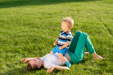 Happy woman and child having fun outdoor on meadow