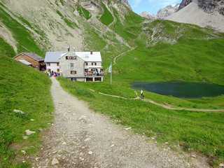 Arriving at Rappenseehütte Germany on stony path. Rappensee with Rappensee hut