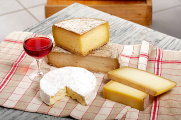 Different french cheeses with a glass of wine