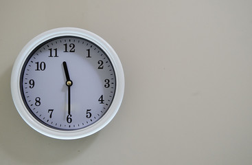 Time of the wall clock hung on a wall is 11:30.