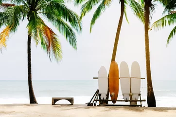 Fotobehang Palmboom Surfplank en palmboom op strandachtergrond.