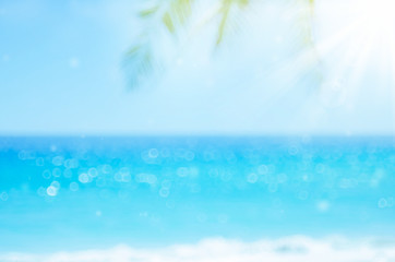 Obraz na płótnie Canvas Blur beautiful nature green palm leaf on tropical beach with bokeh sun light wave abstract background.