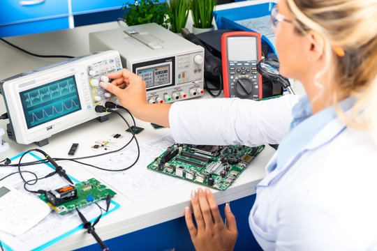 Female electronic engineer using oscilloscope in laboratory