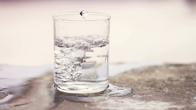 Pouring glass of water in open area