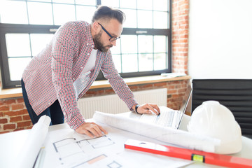 Architect working with blueprints in the office.