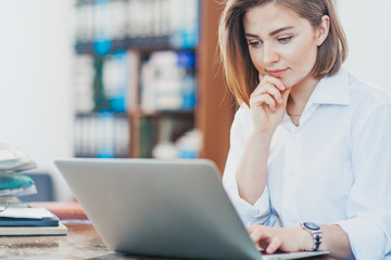Young woman reading from laptop
