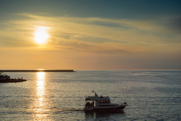 Fototapeta na wymiar beautiful sunset on the coast. the boat runs along the seashore