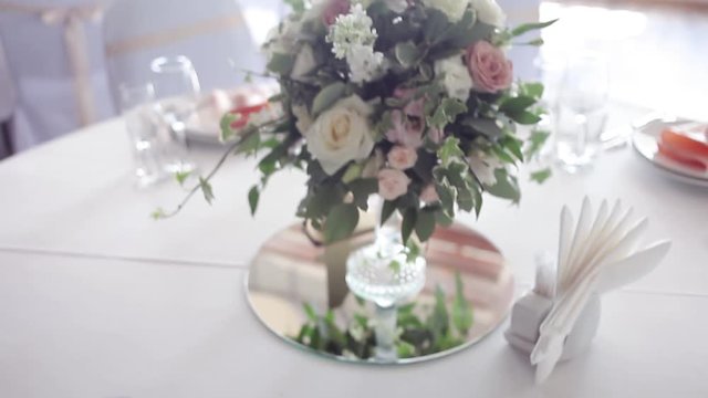 Wedding floristry. Beautiful bouquet on the table, dishes and served table