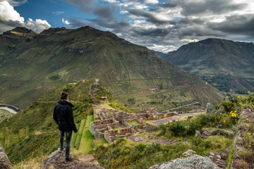 Touristin geniesst Aussicht auf Inka-Ruinen von Pisac, Heiliges Tal der Inkas - obrazy, fototapety, plakaty