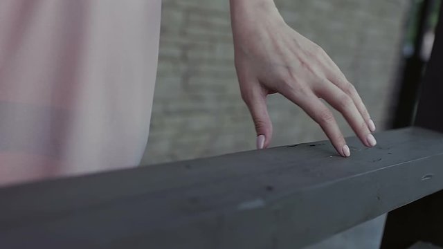 Girl is driving her hand around the railing close up