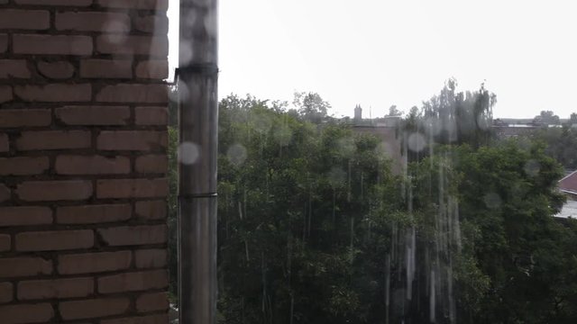 Rain drops falling on window pane