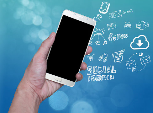 hand holding mobile phone with cloud computing with blue background .Hand holding smartphone with hand drawn media icons and symbols concept style. - Powered by Adobe