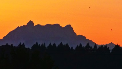 Berg und Wald vor Sonnenaufgang mit orangem Himmel