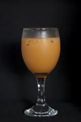 Cold tea in the glass on black floor.