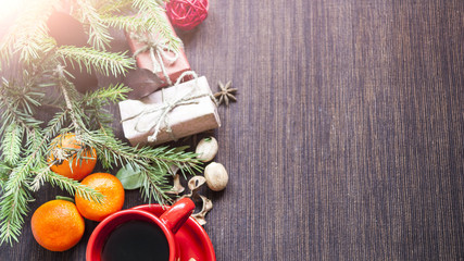 New Year's gifts spruce twigs and cup of coffee on a dark background concept of New Year's holidays
