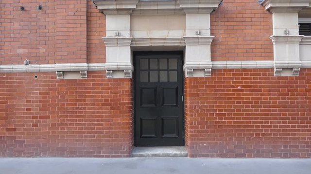 The black door in a red brick building.