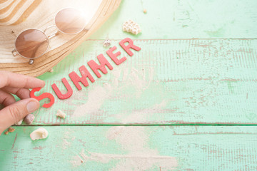 Summer background,Sand and seashells with SUMMER word made from red wooden letters