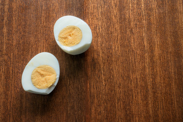 Hard boiled egg divided in half on wooden dining table