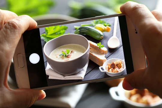 hands with smartphone photographing food