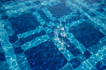 Swimming pool bottom with blue square tile ornaments