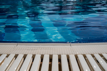 Edge of the swimming pool with drainage grate closeup