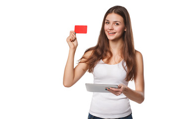 Smiling woman showing blank credit card hold tablet pc in hand, in white t-shirt, isolated over...
