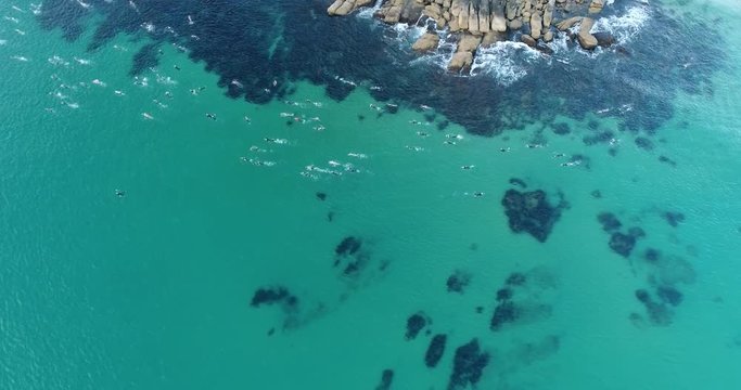 Tipping point of cliffs and boulders passed by a group of recreational swimmers on a race from Manly beach to Shelly beach.
