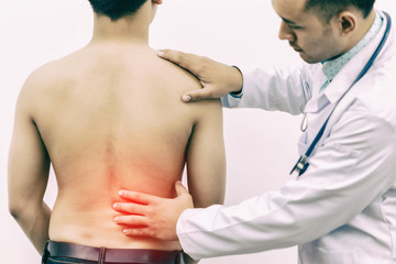 Doctor touches the back plate for causes of back pain with stethoscope on hospital. Concept of...