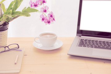 Minimal workspace,computer laptop,coffee cup,orchid flower and notebook on wooden table over white background