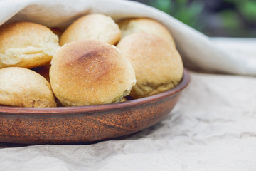 Homemade breads or bun In a clay plate on wood background. Homemade baking