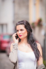 Cute girl using cellphone on the street.