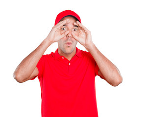 Surprised delivery man using his hands like a binoculars