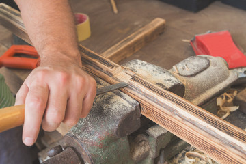 Male carpenter working on raw wood / boards / plank.