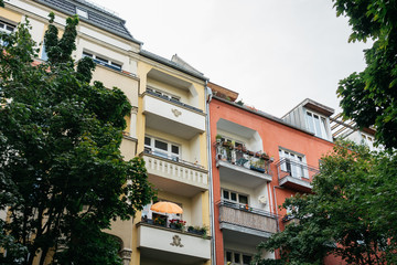 yellow and red houses in berlin framed by trees