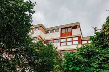 red apartment building inbetween of green trees