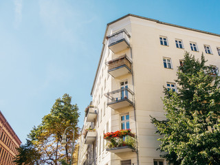 white corner house in a street next to an brick building