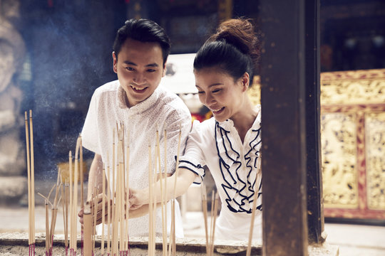 Lovely couple placing their joss sticks in a temple in Singapore